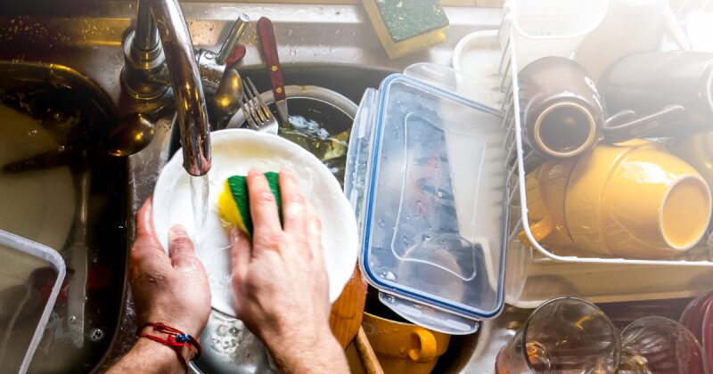 男性が食器洗いをしている写真