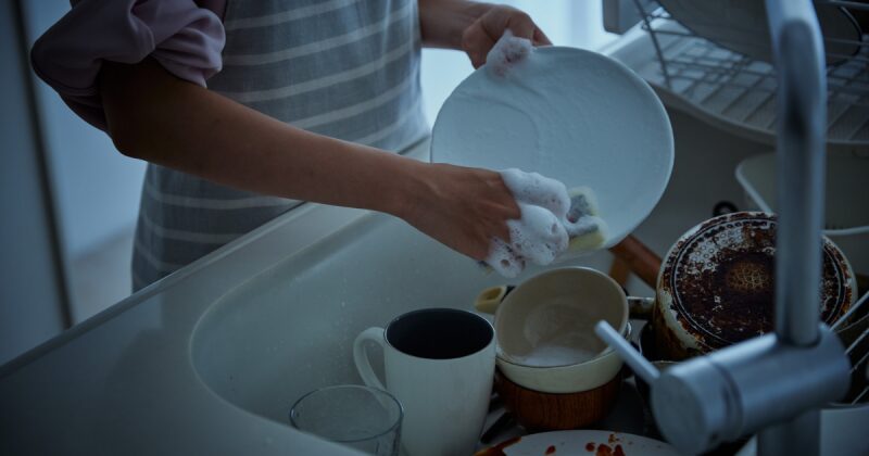 沢山の洗い物をしている女性の写真